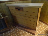 (DEN) WOODEN BAR; WOOD BAR WITH 2 SHELVES ON THE BACK SIDE AND HARD WOOD PANELING ON THE FRONT.