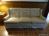 (DEN) WINGBACK SOFA; WHITE UPHOLSTERED SOFA WITH BLUE LEAF DETAILING. HAS BUTTON TUFTED BACK, ROLLED