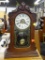 (R2) WOODEN TABLE CLOCK; TABLE CLOCK WITH DETAILED SCROLL CARVINGS AND A FLORAL AND SCROLL DETAILED