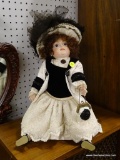 (R1) VINTAGE DOLL; VINTAGE CURLY HAIRED DOLL WITH A WHITE AND BLACK DRESS HOLDING A LOCKING PURSE.