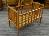 (R4) VINTAGE CRIB; VINTAGE WOODEN CRIB ON CASTERS. MISSING A WHEEL. MEASURES 2 FT 4.5 IN X 1 FT 4 IN