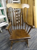 (R4) ROCKING CHAIR; WOODEN ROCKING ARMCHAIR WITH A BANNISTER BACK. HAS A ROUNDED FRONT AND TAPERED