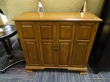 (R5) WOODEN CABINET; WOOD GRAIN CABINET WITH 2 BI-FOLD OPENING DOORS WITH METAL KNOBS THAT OPENS TO