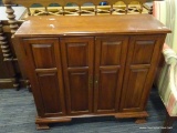 WOODEN CABINET; MAHOGANY CABINET WITH 2 BI-FOLD OPENING DOORS WITH METAL KNOBS THAT OPENS TO REVEAL