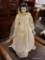 (R2) PORCELAIN DOLL; VINTAGE PORCELAIN DOLL WITH BLACK HAIR AND A WHITE WEDDING DRESS. MEASURES 22