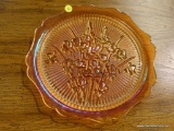 (R2) ORANGE GLASS PLATE; GLASS PLATE WITH FLOWERS CARVED INTO THE MIDDLE AND A RIBBON TEXTURE ON THE