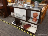 (R3) DISPLAY CABINET; 2 SIDED GLASS PANELED ON A WOODEN FRAME DISPLAY CASE WITH 3 SHELVES THAT HAVE