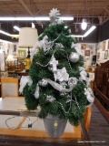 (R3) MINIATURE X-MAS TREE; IS IN A SILVER TONED PLANTER AND HAS SILVER TONED ORNAMENTS AS WELL AS