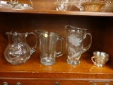 (R1) LOT OF GLASS PITCHERS AND CUP; 4 PIECE LOT TO INCLUDE 3 LARGE GLASS PITCHERS, ONE HAS ETCHED