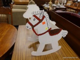 (R4) ROCKING HORSE BOOK HOLDER; WHITE PAINTED WOODEN ROCKING HORSE WITH A BASKET IN THE MIDDLE THAT