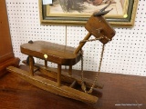 (R1) ROCKING HORSE; DARK WOODEN ROCKING HORSE WITH YARN TAIL AND REINS. MEASURES 2 FT X 16 IN.