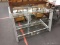 (R2) GLASS TV STAND; GLASS PANELED GRAY METAL TV STAND WITH 3 GLASS SHELVES. MEASURES 3 FT 5.5 IN X