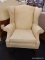 (R3) WINGBACK CHAIR; YELLOW UPHOLSTERED WING BACK ARM CHAIR SITTING ON 4 LEGS WITH REEDED DETAILING