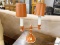 (R3) TABLE LAMP; ORANGE AND WHITE MATTE FINISHED METAL TABLE LAMP WITH 2 FAUX CANDLE STICK FIXTURES.