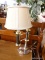 (R3) TABLE LAMP; CHROME AND BRASS TABLE LAMP WITH AN ARM THAT HOLD THE LIGHT FIXTURE. COMES WITH A