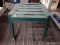 (R3) PLASTIC BENCH; GREEN PLASTIC PATIO BENCH. MEASURES 17.5 IN X 17.5 IN X 15.5 IN.