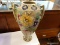 (R1) FLOWER VASE; LARGE HAND PAINTED FLORAL FLOWER VASE WITH A GREEN BASE. MEASURES 16.5 IN TALL.