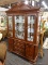 (R2) RIVER'S EDGE CHINA CABINET; 2 PC. CHINA CABINET WITH AN ARCHED TOP WITH A PINEAPPLE SHAPE IN