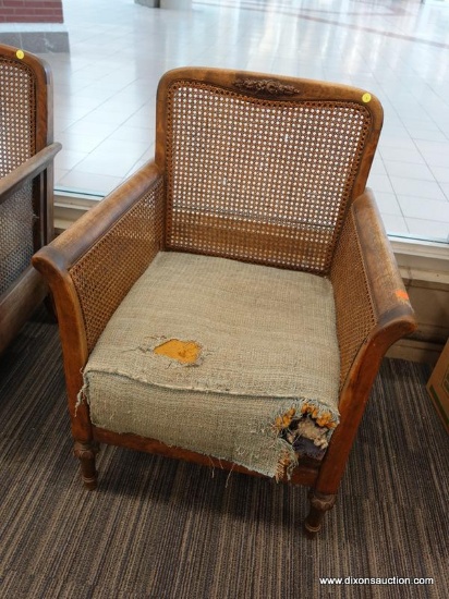 (DOOR) WICKER ARMCHAIR; WOODEN ARMCHAIR WITH A WICKER LACED BACK AND SIDES. HAS A FADED BLUE FABRIC,