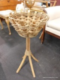 (R2) FLOOR BASKET; WOVEN BASKET ON A PEDESTAL WITH 4 FLARED LEGS. MEASURES 27 IN TALL WITH AN 11.5