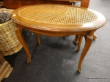 (R3) BENCH; OVAL WOODEN BENCH WITH A CANE SEAT AND 4 CABRIOLE LEGS ORNATE BRONZE ORMOLU ON FEET.