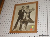 (WALL) FRAMED PHOTO; VINTAGE PHOTO OF 2 PEOPLE DANCING TOGETHER. SITS IN A WOODEN FRAME. MEASURES 1