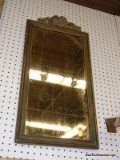 (WALL) WALL HANGING MIRROR; HAS A RIBBON AND FLOWER CARVED TO AND FRAMED IN A GREEN PAINTED WOODEN