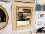 (WALL) WALL HANGING MIRROR; MIRROR SITS IN A CREAM AND ORANGE PAINTED FRAME WITH FLORAL CARVED