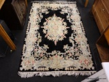 (R1) XIAN ARTS & CRAFTS RUG; BLACK RUG WITH A FLORAL DESIGN. HAS TASSELS ON 2 ENDS. MEASURES 4 FT X