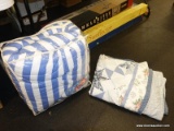(TABLE) BAG LOT OF BED LINENS; LOT INCLUDES A BLUE AND WHITE STRIPED REVERSIBLE COMFORTER, AND A