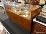 (R1) DISPLAY CASE; WOODEN DISPLAY CASE WITH GLASS ON THE TOP AND THE FRONT, 4 SLIDING DOORS ON THE