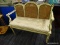 (R3) CAMELBACK BENCH; GREEN AND CREAM PAINTED WOODEN BENCH WITH A CANE SEAT REST AND 3 PANELED CANE