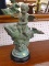 (R1) VINTAGE STONE STATUE; ANGEL BABY RIDING A FISH OUT OF WATER. SITS ON A WOODEN STAND. MEASURES