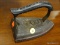 (R1) CAST IRON IRON; HAS LETTERS ENGRAVED ON THE HANDLE. MEASURES 6.5 IN LONG.