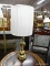 (R4) BRASS TABLE LAMP; HAS A CYLINDRICAL SHAPED SHADE AND BRASS FINIAL. IS IN EXCELLENT CONDITION
