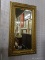 (WALL) LARGE FRAMED MIRROR; HAS A 1 IN BEVEL ON THE GLASS AND IS IN A GOLD GILT FRAME. MEASURES 28