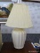 (WALL) TABLE LAMP; CREAM CERAMIC TABLE LAMP WITH A SHELL LIKE OUTSIDE AND A CREAM SHAPED LAMP SHADE.