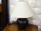 (R2) TABLE LAMP; BLACK PAINTED METAL TABLE LAMP WITH A BEIGE LINEN COOLIE LAMP SHADE. MEASURES 23 IN