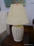 (WALL) TABLE LAMP; CREAM CERAMIC TABLE LAMP WITH A SHELL LIKE OUTSIDE AND A CREAM SHAPED LAMP SHADE.