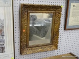 (WALL) WALL HANGING MIRROR; MIRROR SITS IN A FLOWER CARVED, BRONZE TONED MIRROR WITH DENTAL MOLDING
