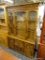 (R4) 2 PC WOODEN CHINA CABINET; TOP PIECE HAS DENTAL MOLDING AROUND THE FLARED CORNICE TOP LEADING