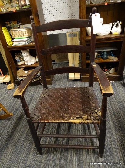 (R1) SLAT BACK ARMCHAIR; CIRCA 1840 ARM CHAIR WITH SPLIT OAK SEAT, TURNED FINIALS, AND AN OLD BROWN