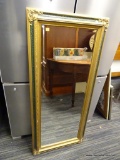 (BACKWALL) FRAMED MIRROR; BEVELED GLASS MIRROR WITH A GOLD TONE AND CRACKED GREEN FRAME. HAS LEAF