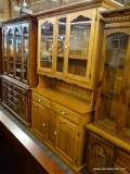 (R4) 2 PC OAK HUTCH; TOP PIECE HAS A FLARED CORNITE TOP SITTING ABOVE 2 GLASS PANELED CABINET DOORS,
