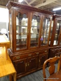 (R4) 2 PIECE WOODEN CHINA CABINET; TOP PIECE HAS A FLARED CORNICE TOP THAT LEADS TO 3 GLASS DOORS
