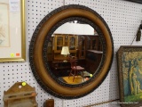 (WALL) ROUND MIRROR; WALL HANGING, ROUND MIRROR SITTING IN A RUSTIC METAL FRAME. HAS A 27.5 IN