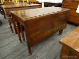(R2) MAHOGANY DROP LEAF TABLE; HAS TURNED LEGS AND 2 19 IN LEAVES. HAS AVERAGE WEAR. MEASURES 20 IN