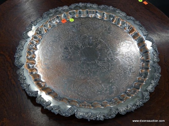 (R1) SILVER ON COPPER SERVING TRAY; HAS SCALLOPED RIM WITH LEAF DETAILING. HAS A 21.5 IN DIAMETER.