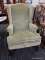 (R3) WINGBACK ARMCHAIR; GREEN UPHOLSTERED WINGBACK CHAIR WITH ROLLING ARMS, CABRIOLE LEGS AND A