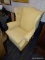 (R5) WINGBACK ARMCHAIR; LIGHT ORANGE/PEACH WINGBACK ARM CHAIR WITH AN H STRETCHER AND REEDED LEGS.